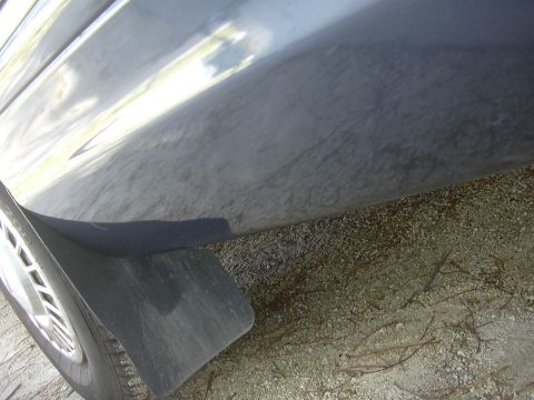 1996 Ford Crown Victoria - Close-up view of the lower side panel and mud flap on a vehicle.