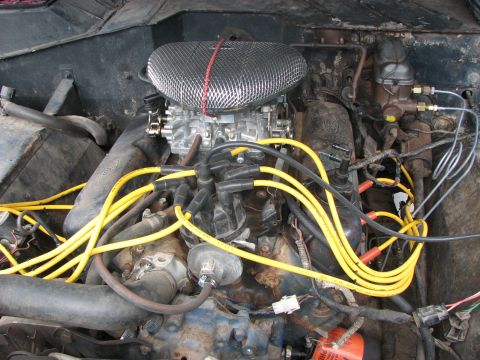 1966 Ford Bronco - Engine bay detail with a V8 motor, carburetor, and yellow spark plug wires visible.