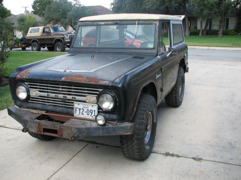 1966 Ford Bronco - A classic first-generation Ford Bronco sits parked on a driveway, with another Bronco visible behind it.
