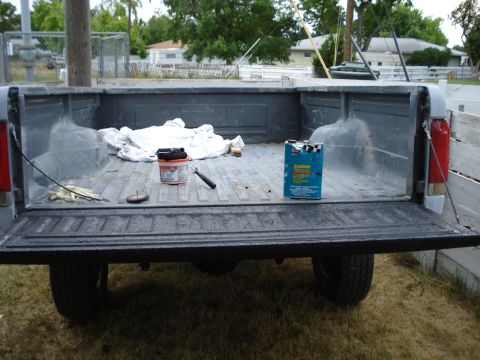 1994 Ford Bronco - Truck bed prepared for coating with paint supplies present.