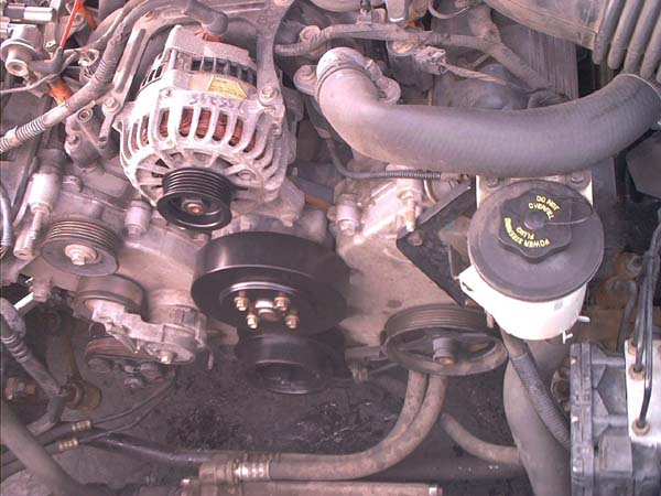 V8 engine front with serpentine belt removed showing crank and alternator pulleys