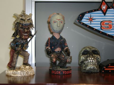 1991 Ford Bronco - A collection of horror movie figures and a skull are displayed on a shelf, with a "SUPERMOTORS" logo visible at the bottom.