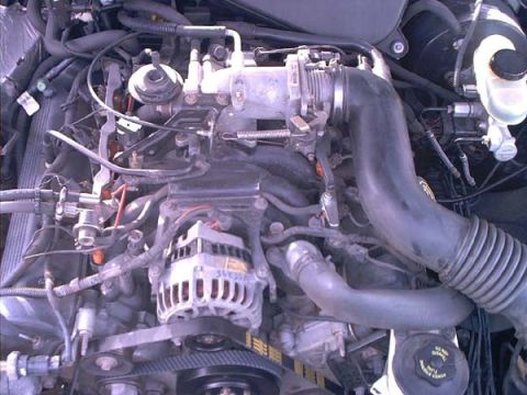 2000 Ford Crown Victoria - Engine bay shot of a modular V8 looking down at the aluminum intake manifold, throttle body, and the alternator marked with handwritten num…