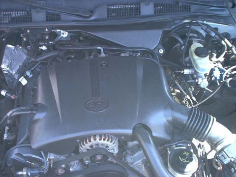 2000 Ford Crown Victoria - Overhead view of a modular V8 engine bay with the black plastic intake manifold cover embossed '4.6' sitting between the cam covers. The al…