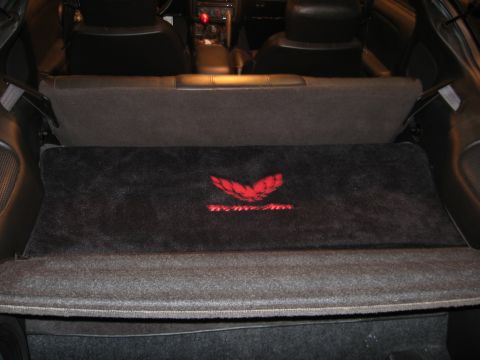 2002 Pontiac Trans Am - The rear interior of a 2002 Pontiac Trans Am, the iconic red bird emblem on the cargo area carpet.