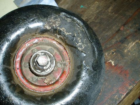 2000 Ford E350 - Close-up of a damaged tire and wheel, showing exposed cords and wear on the tire's sidewall.