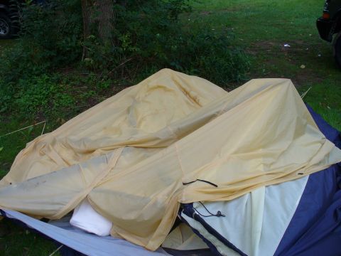 1991 Ford Probe - A camping tent is partially set up in a grassy area with trees in the background.
