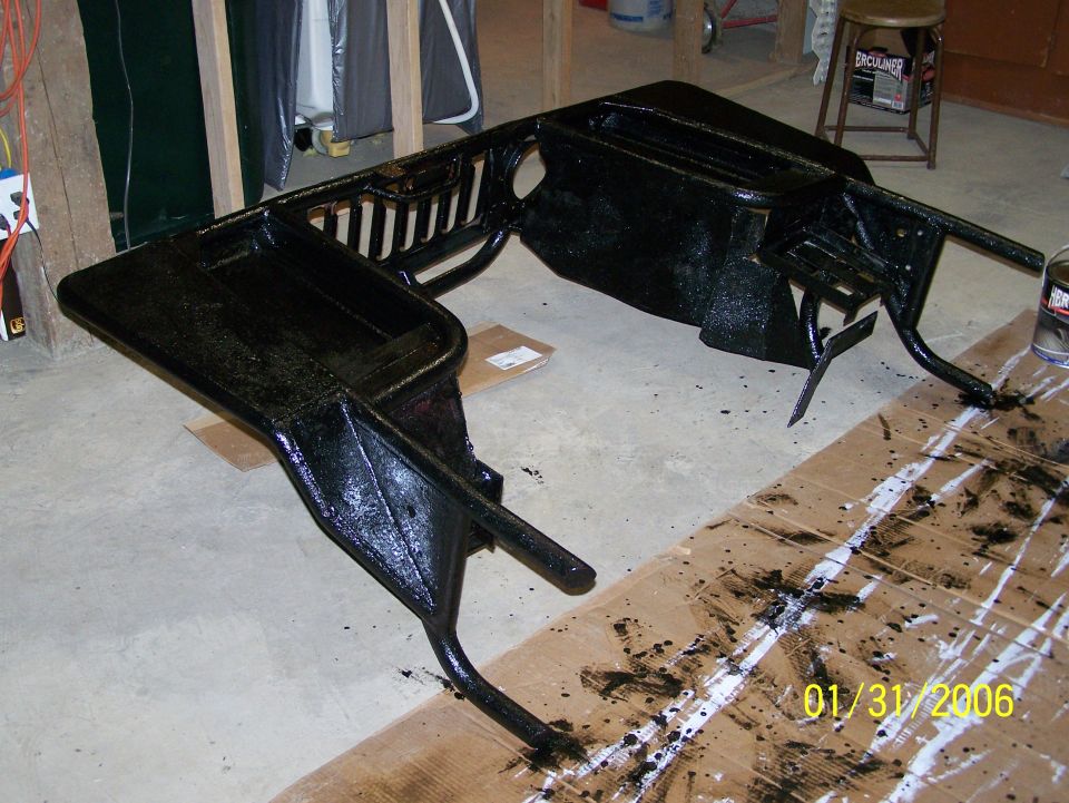 Black painted dashboard frame on concrete floor with paint splatters