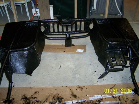 1988 Suzuki Samurai - A black metal frame with a grille is shown on a concrete floor, with paint splatters visible around it.