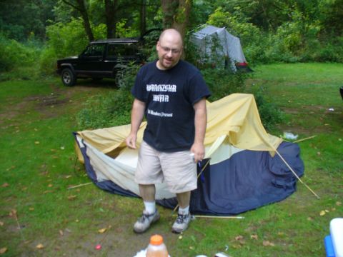 1991 Ford Probe - A black SUV is parked in a grassy area surrounded by trees, with a tent set up nearby.