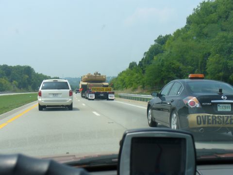 1991 Ford Probe - A flatbed truck carries an oversize load on the highway, with other vehicles visible.