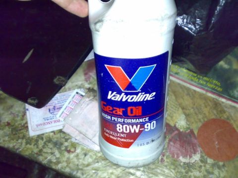 1995 Ford F-150 - Valvoline Gear Oil 80W-90 bottle shown with other items on a cluttered surface.