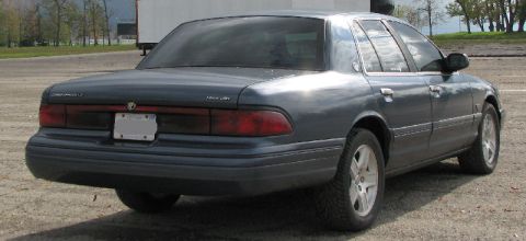 1985 Mercury Grand Marquis - Rear view of a dark blue sedan, likely a 1995 model, with a license plate obscuring identifying marks.