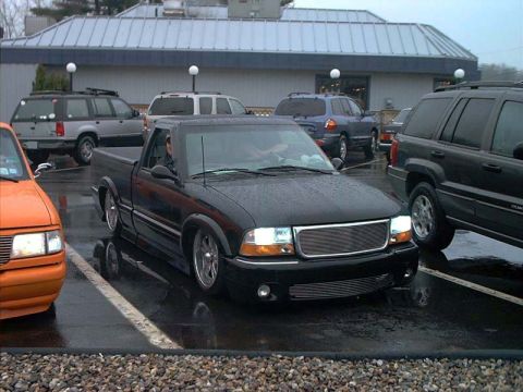 2000 Ford Crown Victoria - A black pickup truck is parked in a lot with other vehicles visible.