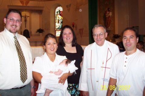 2000 Ford Crown Victoria - A family gathers with a priest for a baptismal ceremony, with a date stamp of 15/08/2007 visible.