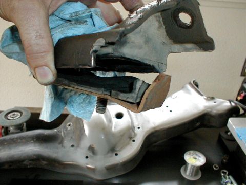 1996 Ford Bronco - A hand holds a worn rubber and metal bracket, likely a component from a vehicle's suspension or engine mount, against a blurred background…