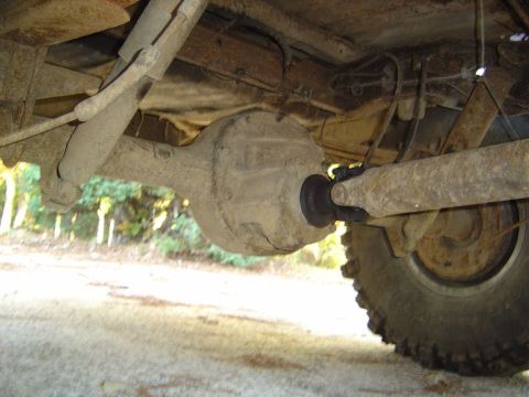 1986 Ford Bronco - Close-up view of the undercarriage of a vehicle, focusing on the rear axle and suspension system.