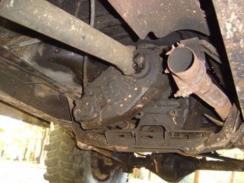 1986 Ford Bronco - Close-up of a vehicle's undercarriage, focusing on mechanical parts and exhaust parts.