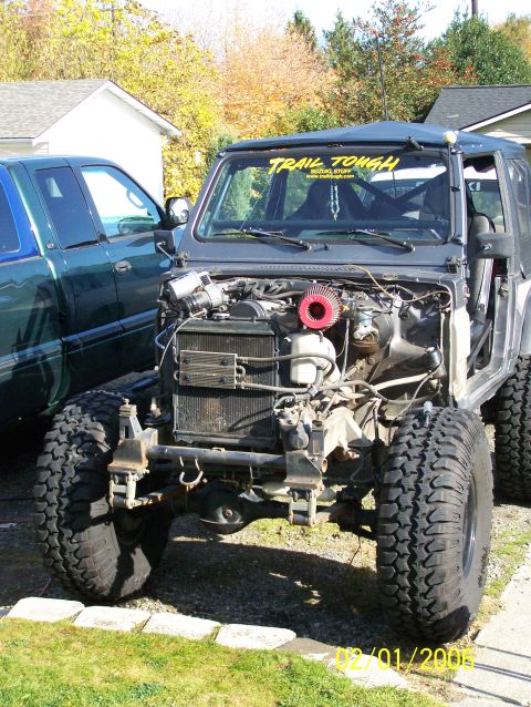 1988 Suzuki Samurai - A gray 1988 Suzuki Samurai is parked in a driveway with its engine compartment open, next to a green pickup truck.