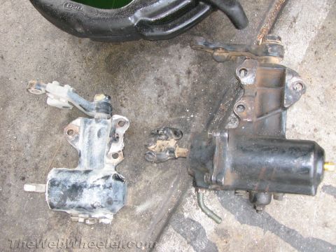 1987 Suzuki Samurai - Two power steering components are shown, one black and one gray, on a concrete surface.