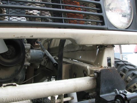 1987 Suzuki Samurai - Close-up view of the front bumper and exposed engine components of an off-road vehicle.