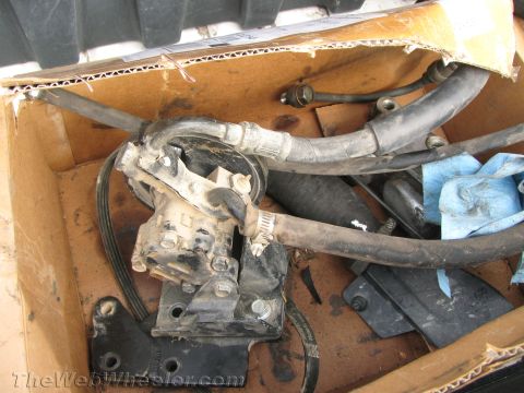 1987 Suzuki Samurai - Power steering pump and associated hoses are pictured inside a cardboard box.