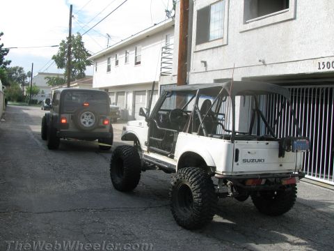1987 Suzuki Samurai - A modified Suzuki Samurai is being towed by a Jeep down an alleyway.