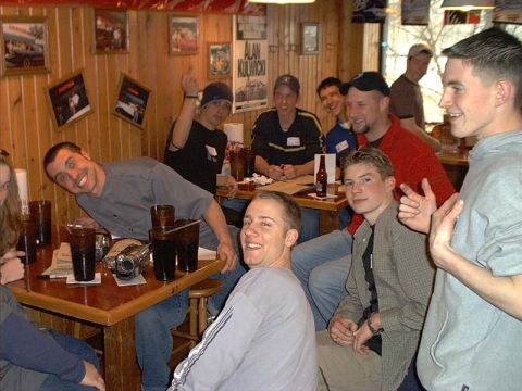 2000 Ford Crown Victoria - Several people are gathered around tables inside a dimly lit establishment.
