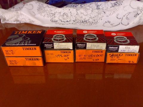 1995 Ford F-150 - Four stacks of new Timken tapered roller bearing boxes and National Federal-Mogul oil seal boxes arranged on a glossy wood table, with part…