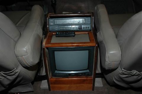 1995 Ford C-350 (Centurion Conversions) - This photo shows the interior of a vehicle, focusing on a console with entertainment electronics.