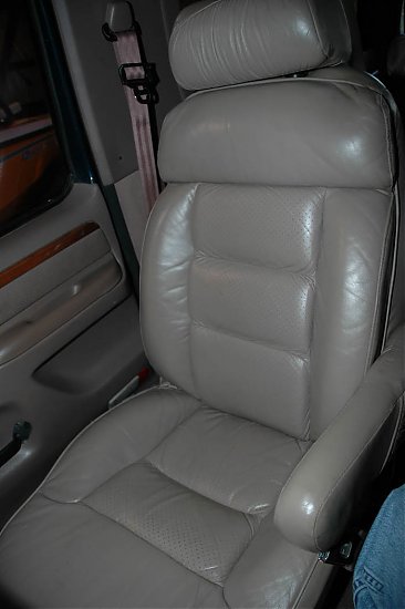 1995 Ford C-350 (Centurion Conversions) - Interior view of a tan leather captain's chair with a visible seatbelt and door panel trim.