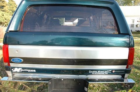 1995 Ford C-350 (Centurion Conversions) - The rear of a Ford pickup truck, a camper shell and a 'Nautiques' decal on the tailgate.