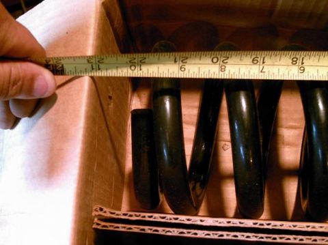 1986 Ford Bronco - Coil spring being measured with a tape measure in a box.
