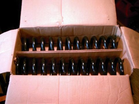 1986 Ford Bronco - Two rows of black coil springs are packed inside a cardboard box.