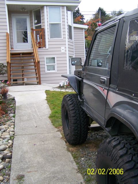 1988 Suzuki Samurai - A 1988 Suzuki Samurai with off-road tires is parked on a gravel surface next to a house.