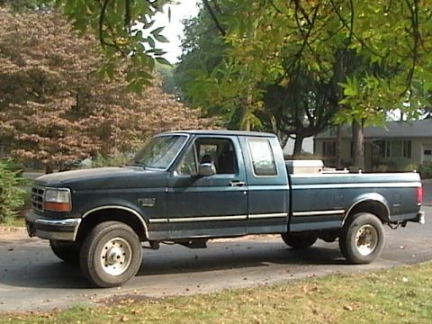 1990 Ford Bronco - This Ford F-250 pickup truck is parked on a residential street with trees in the background.