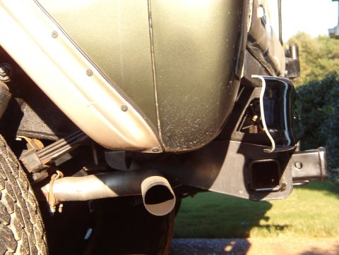 1975 Ford Bronco - Close-up view of the rear bumper and hitch receiver of a vehicle, with visible exhaust pipe.