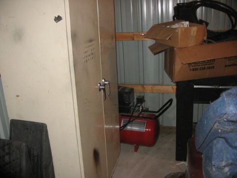 1900 Ford Wagon - An air compressor and storage cabinet are visible in a workshop setting with stacked boxes.