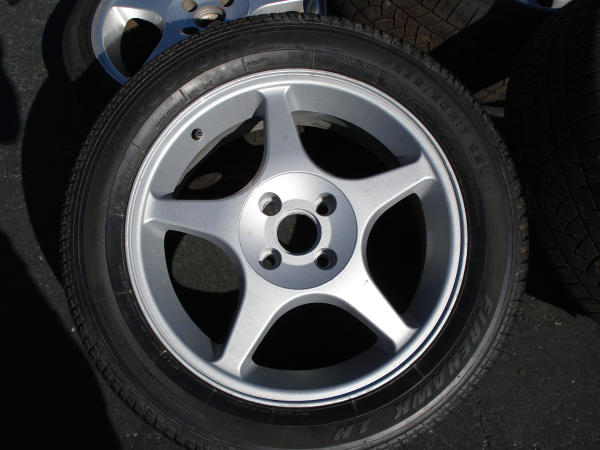Five-spoke alloy wheel with Firehawk tire. Supermotors.net logo visible