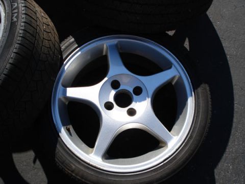 1979 Ford Bronco - A silver alloy wheel with a tire is shown, with other tires in the background.