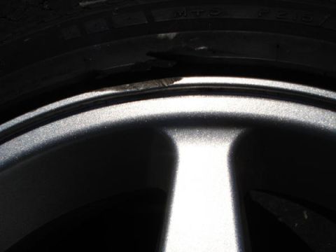 1979 Ford Bronco - Detail of a tire and wheel, showing damage on the tire's sidewall.