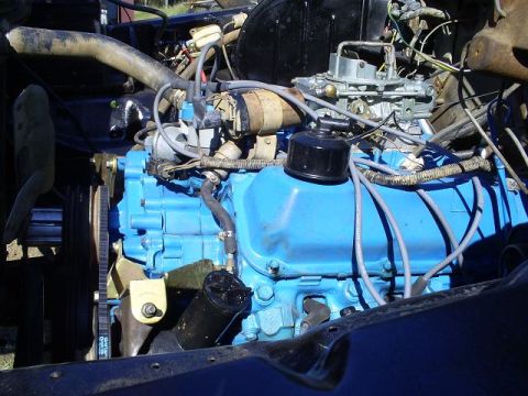 1979 Ford Bronco - Close-up view of an engine bay, showing the engine block, carburetor, and various hoses and wires.