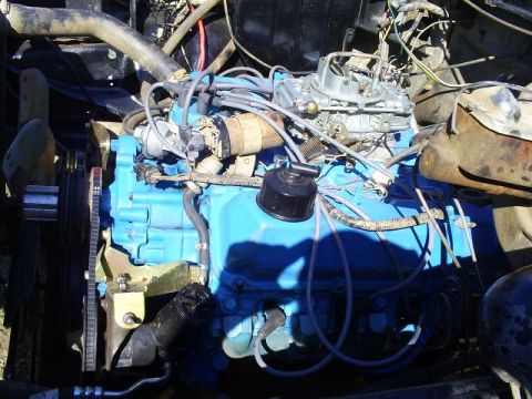 1979 Ford Bronco - The engine bay shows a blue painted engine block with various hoses and wires connected.