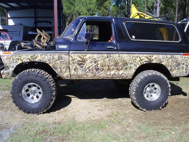Black Ford Bronco with camouflage body wrap, lifted suspension, and off-road tires