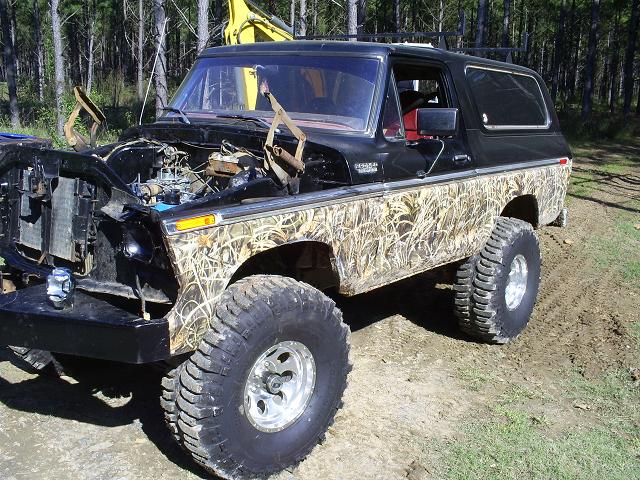 Modified Ford Bronco with camouflage body panels and lifted suspension