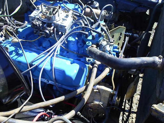 Blue painted engine with carburetor, hoses, and fan visible