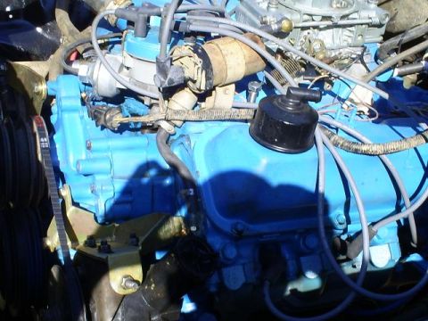 1979 Ford Bronco - Engine bay detail with blue painted block, carburetor, and distributor cap visible.