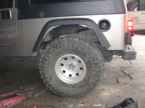 1987 Suzuki Samurai - The rear section of a tan Jeep Wrangler is shown, with a second Jeep partially visible in the background.