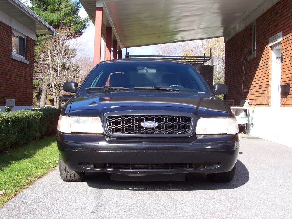 Black 2003 Ford Crown Victoria front view, parked under a covered driveway