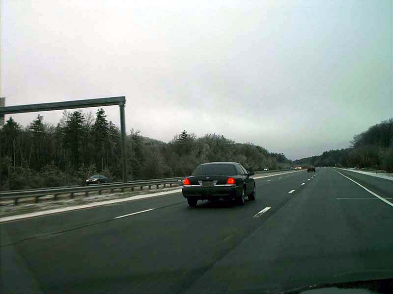 Black 2000 Ford Crown Victoria driving on highway